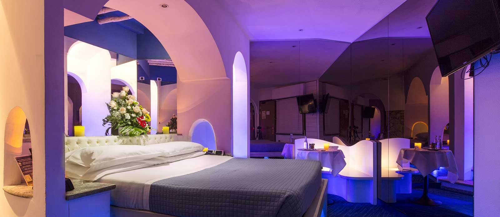 Motel K Junior Suite Santorini Motel K Junior Suite Santorini Motel K Junior Suite Santorini vista su letto matrimoniale con giochi di specchi particolari vasca dietro al letto vista su letto matrimoniale, specchi che circondano il perimetro della camera, servizio candele in suite, camera a tema isole greche